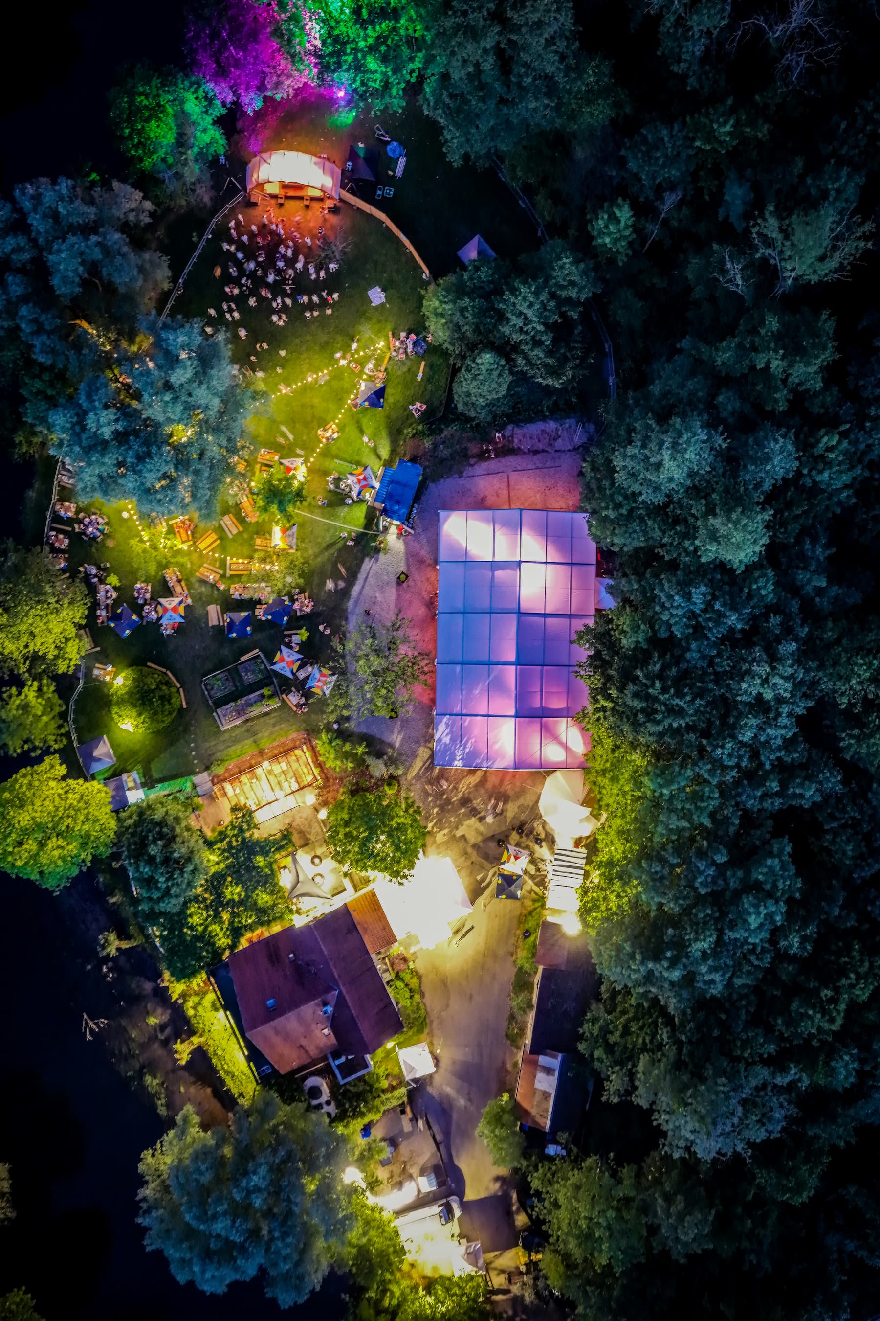 Événement nocturne en forêt avec éclairage coloré, vue aérienne zénithale